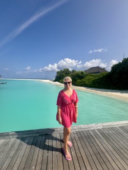 me in pink dress on decking over beach